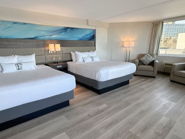 Hotel guestroom with two queen beds and a blue wall mural