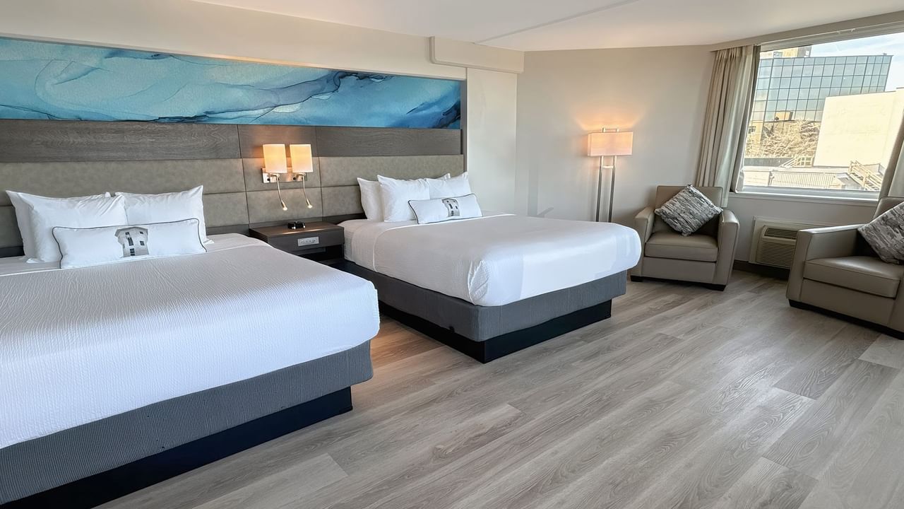 Hotel guestroom with two queen beds and a blue wall mural