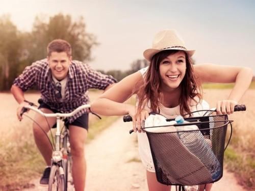 A couple riding bicycles along a dirt road & enjoying at Irazu Hotel