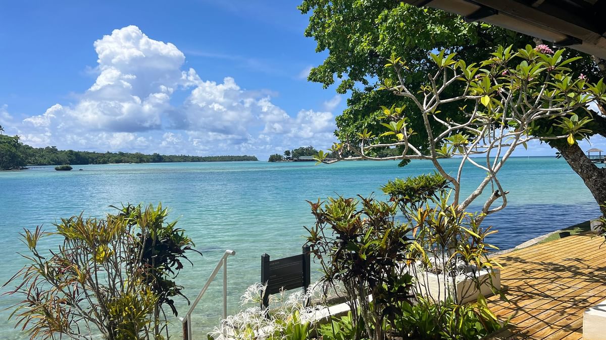 Wooden deck and lush greenery overlooking tranquil blue ocean at Warwick Le Lagon Efate.
