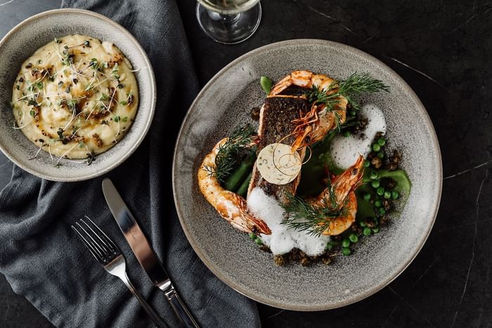 Close-up of dishes served with wine in the restaurant at Freycinet Lodge