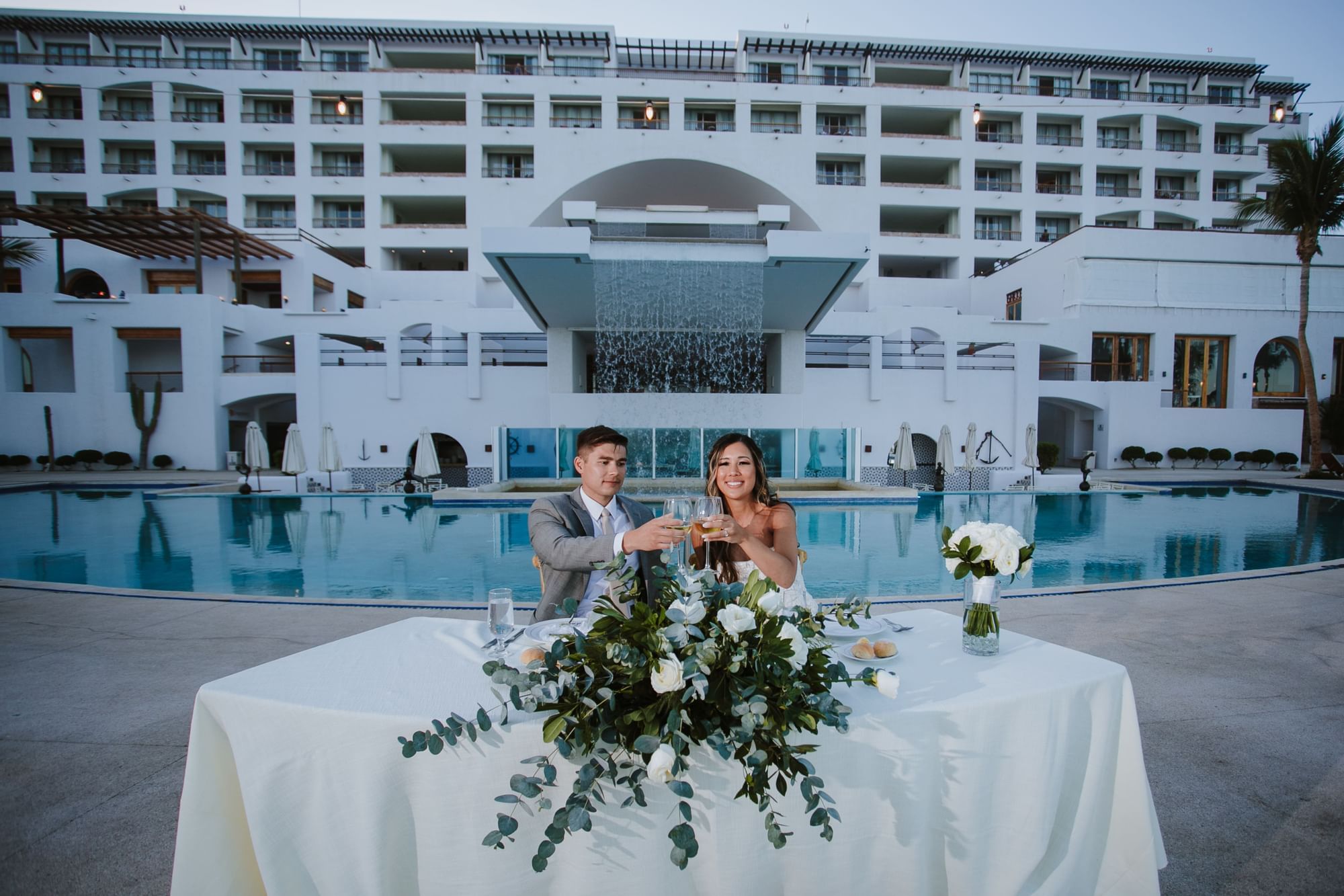 A wedding couple sitting at a dining table in Marquis Los Cabos