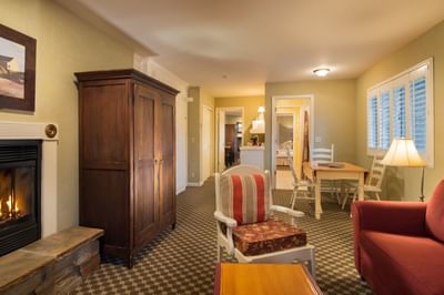 Suite living room with couch, dining area, and fireplace