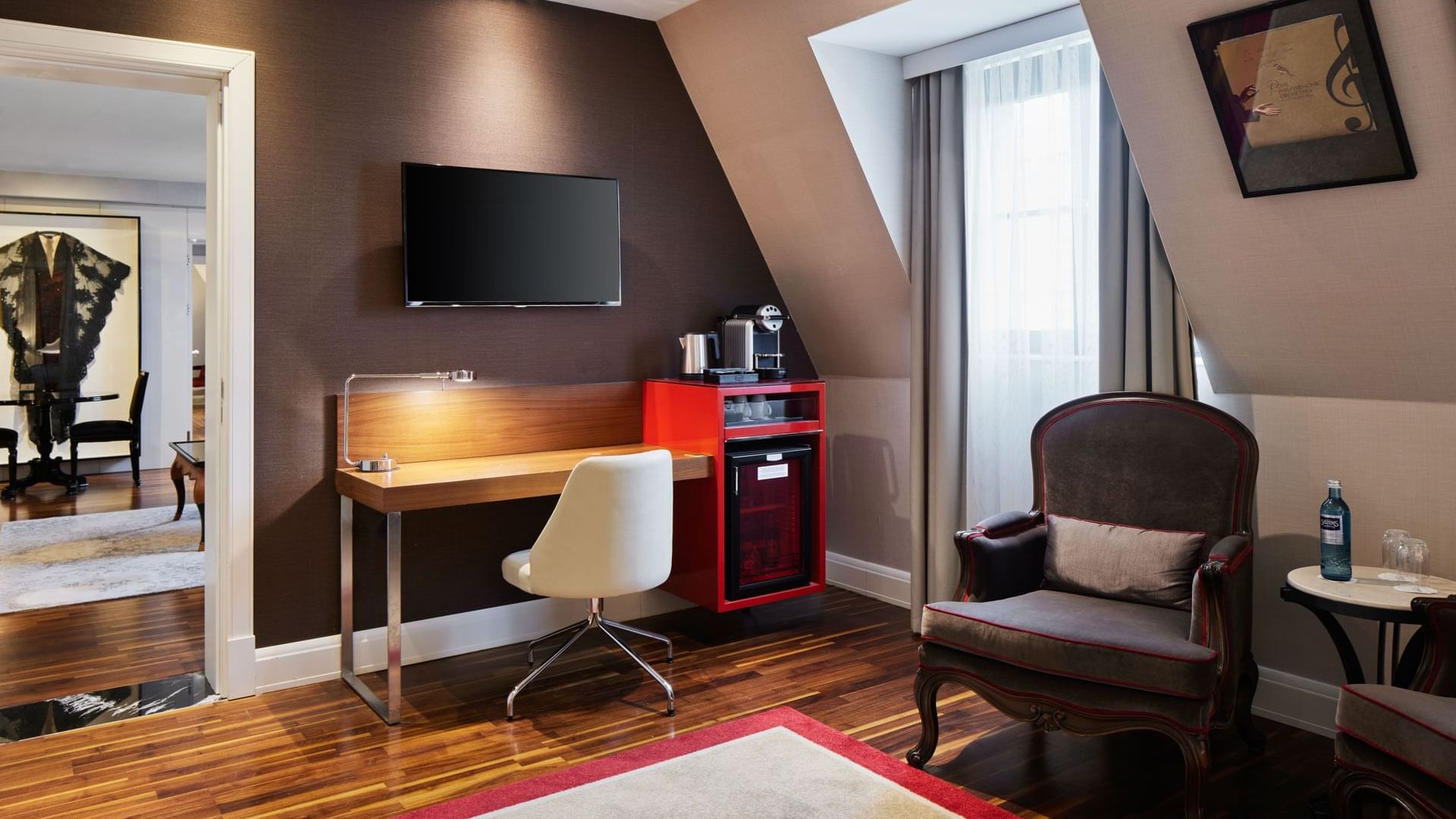 Work desk by TV lounge area with wooden floor in Sezen Aksu Suite at Titanic Gendarmenmarkt Berlin