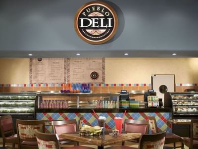 Interior of The Pueblo Deli at Hilton Santa Fe Buffalo Thunder with menu displays and tables set with drinks