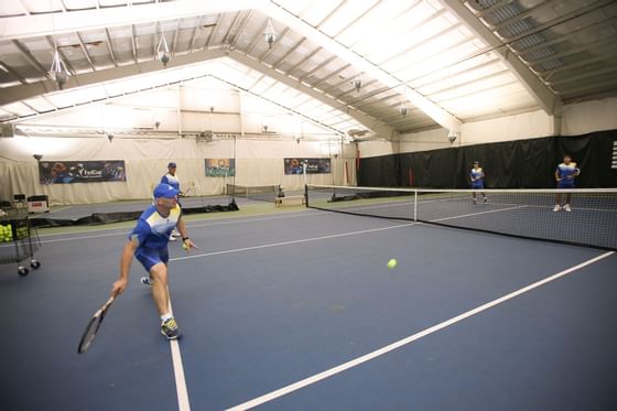 Players participating in a tennis game on a court at Topnotch Stowe Resort