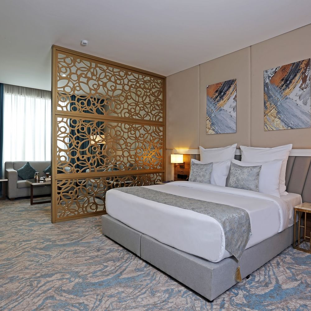 Elegantly decorated Junior Suite with large bed and modern decor at Cantonal Hotel by Warwick Riyadh.