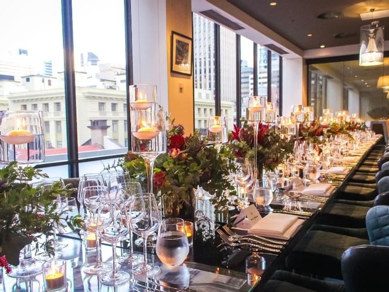 Dining table setup with candles, glassware, and a floral centerpiece in Prive at Sofitel Brisbane Central