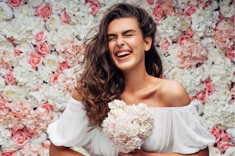 Lady with bouquet smiling & posing at Amora Hotel Sydney