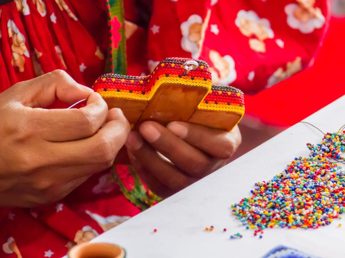 Close-up of a lady making bead craft at Gamma Hotels