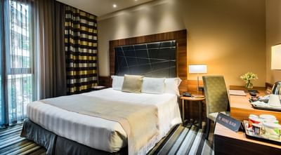 Bed and work desk in Classic Single room at Uptown Palace