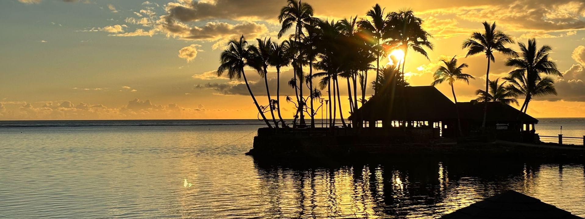 Sunset view of Wicked Walu restaurant with ocean and palm trees at Warwick Fiji Resort and Spa, Korolevu