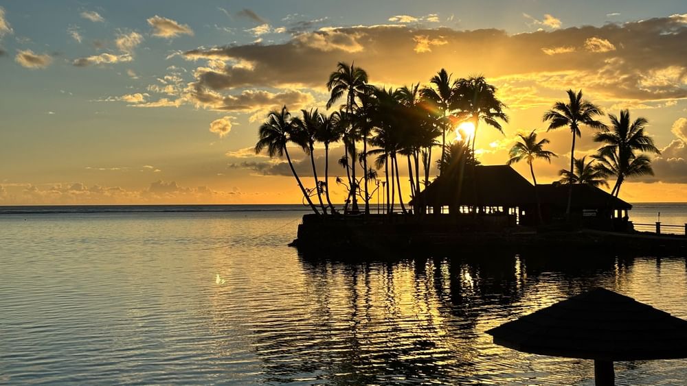 Sunset view of Wicked Walu restaurant with ocean and palm trees at Warwick Fiji Resort and Spa, Korolevu.