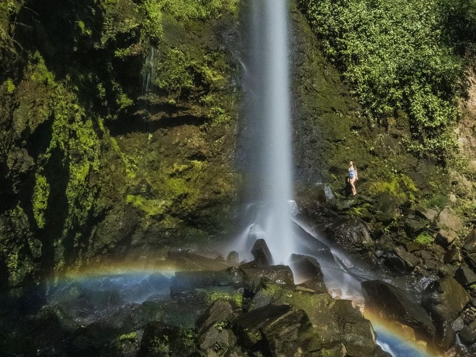 Lady posing by waterfall & rainbow near Buena Vista Del Rincon