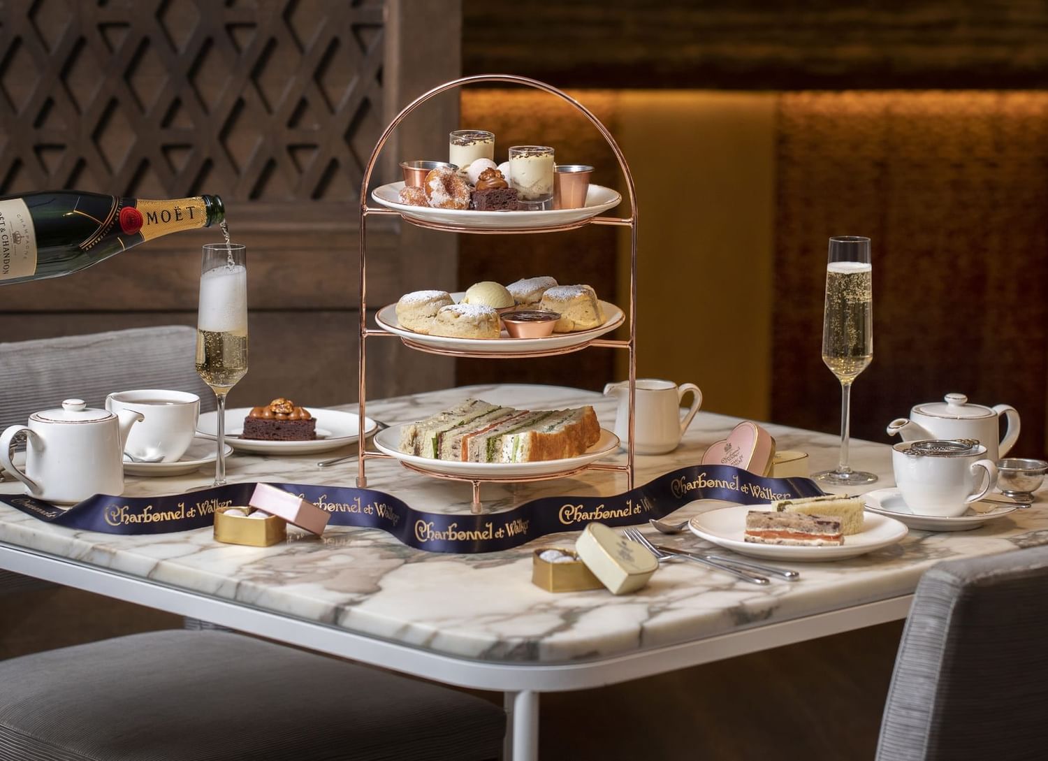 Afternoon tea curate stand with tasty treats, ceramic teapots, cups & champagne served at The May Fair Hotel, London