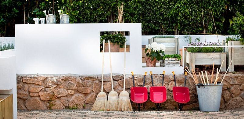 Brooms, shovels & bins by a wall at the garden in Marbella Club