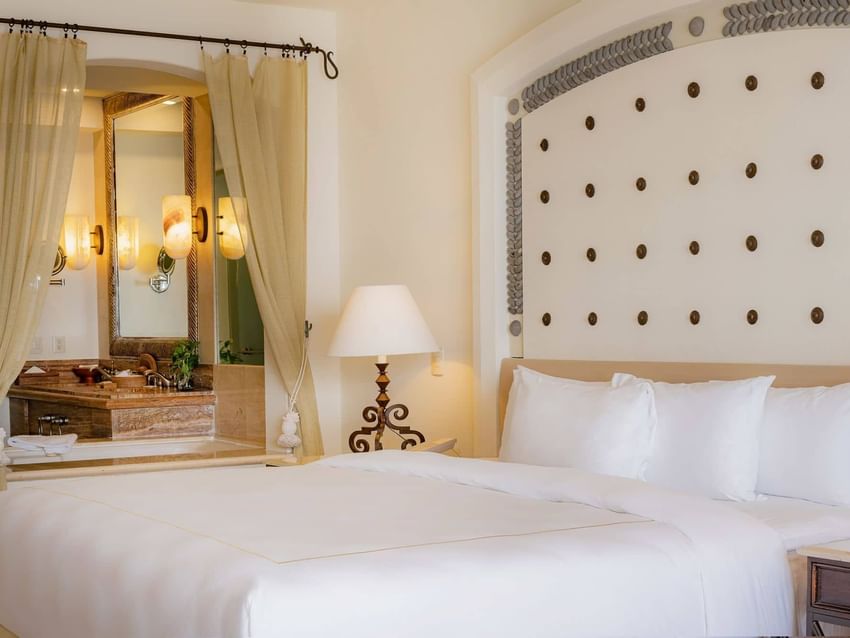 King-sized bed and an open view to the bathroom area in Junior Suite Ocean View at Marquis Los Cabos Resort