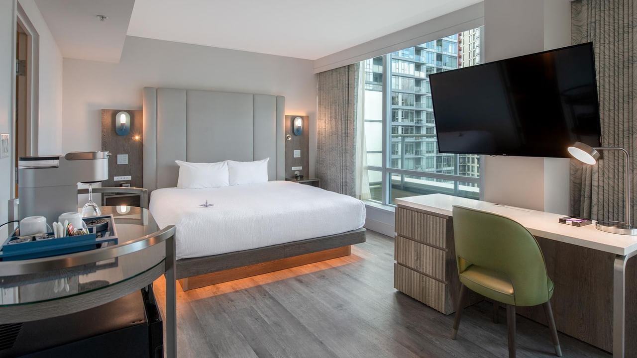 Hotel room with King bed, balcony, and city view.