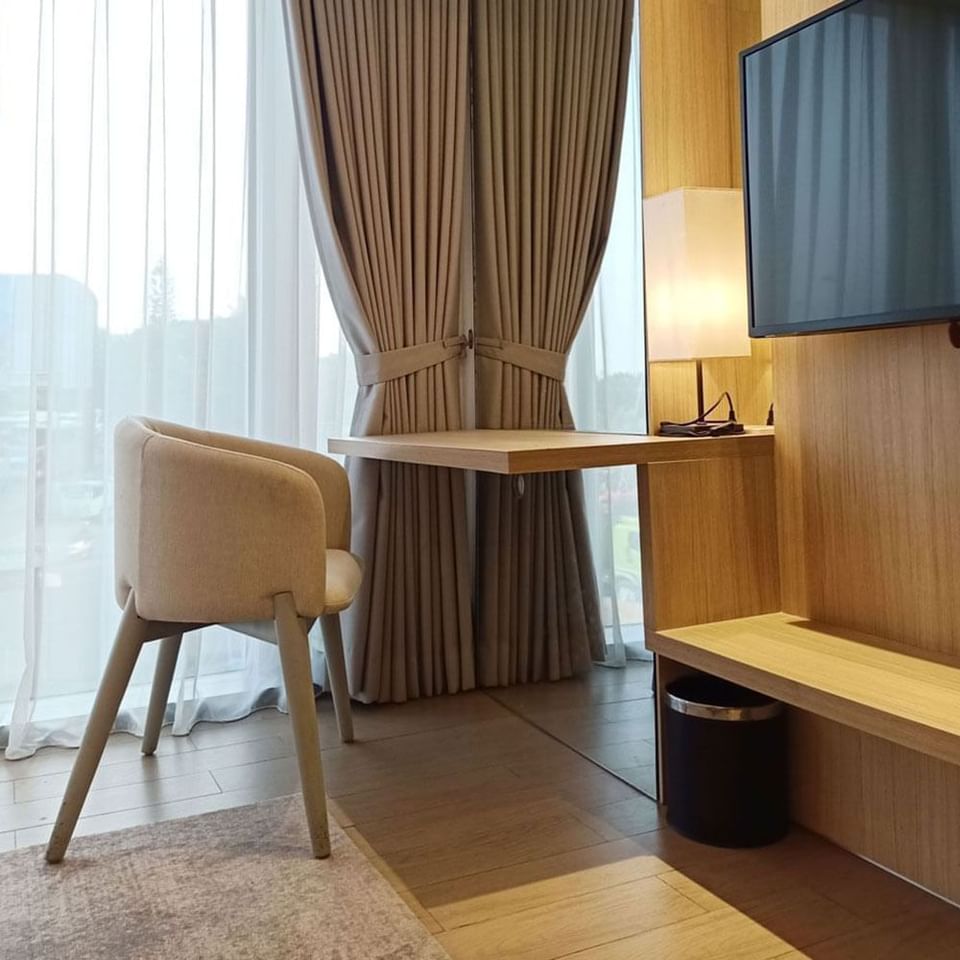 TV and seating area in King Bed Deluxe Room in LK Cikarang Hotel & Residences