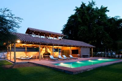 Pool & pavilion lounge chairs beside a stone patio under a tiled roof at NOI Blend Colchagua, Valley