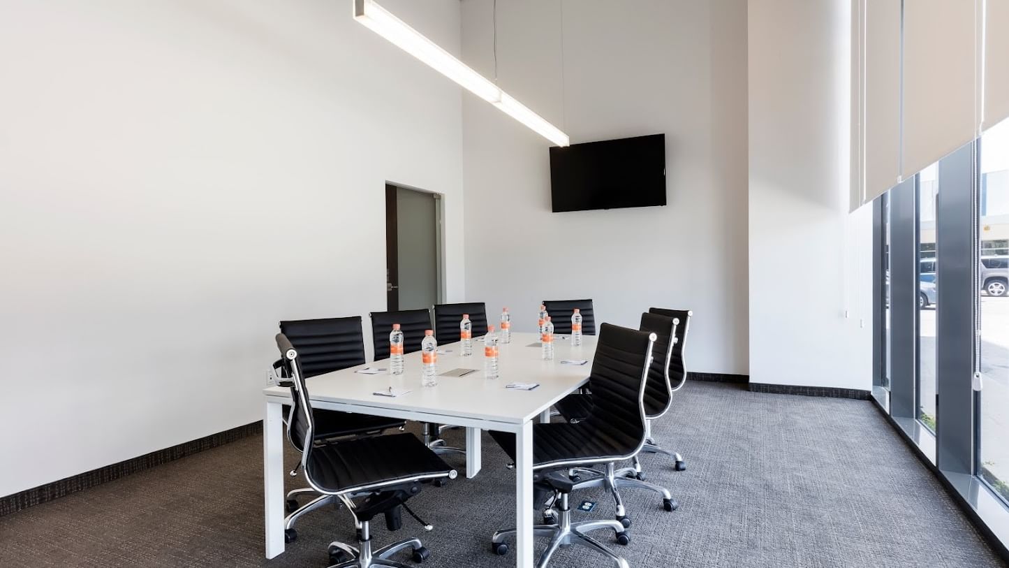 Meeting room at Fiesta Inn Express Cancún Cumbres with chairs & a table facing the wall-mounted TV, Cancun meeting space