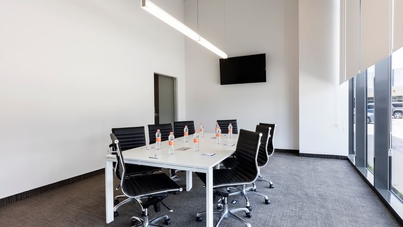 Meeting room at Fiesta Inn Express Cancún Cumbres with chairs & a table facing the wall-mounted TV, Cancun meeting space