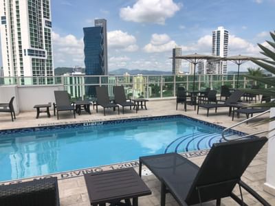 Rooftop pool with lounge chairs, umbrellas, and cityscape at MARINN PLACE Financial District