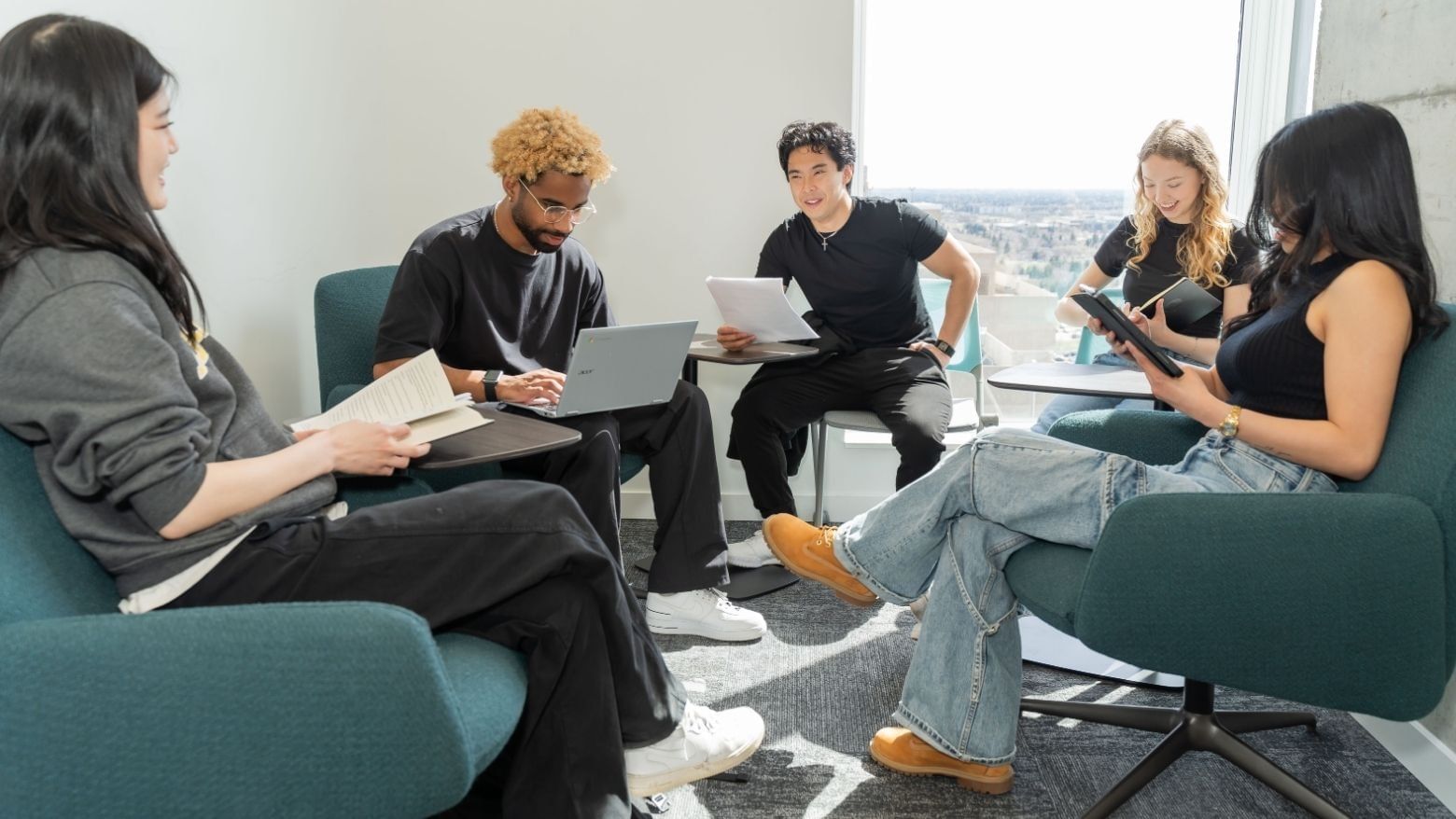 A group of students study together in a bright and modern room overlooking Edmonton.