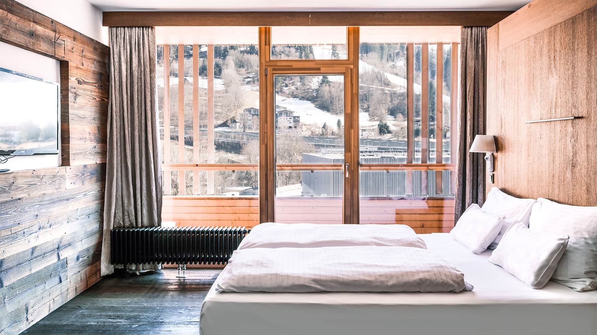 Large bed & view in Dachstein Suite at Falkensteiner Hotels