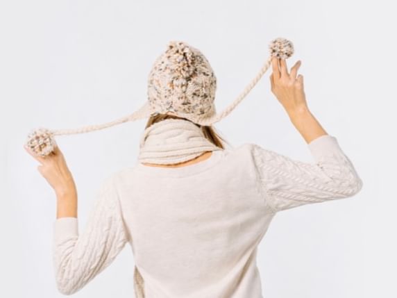 Une femme lève les bras avec une écharpe et le texte Winter Offer by Kenzi.