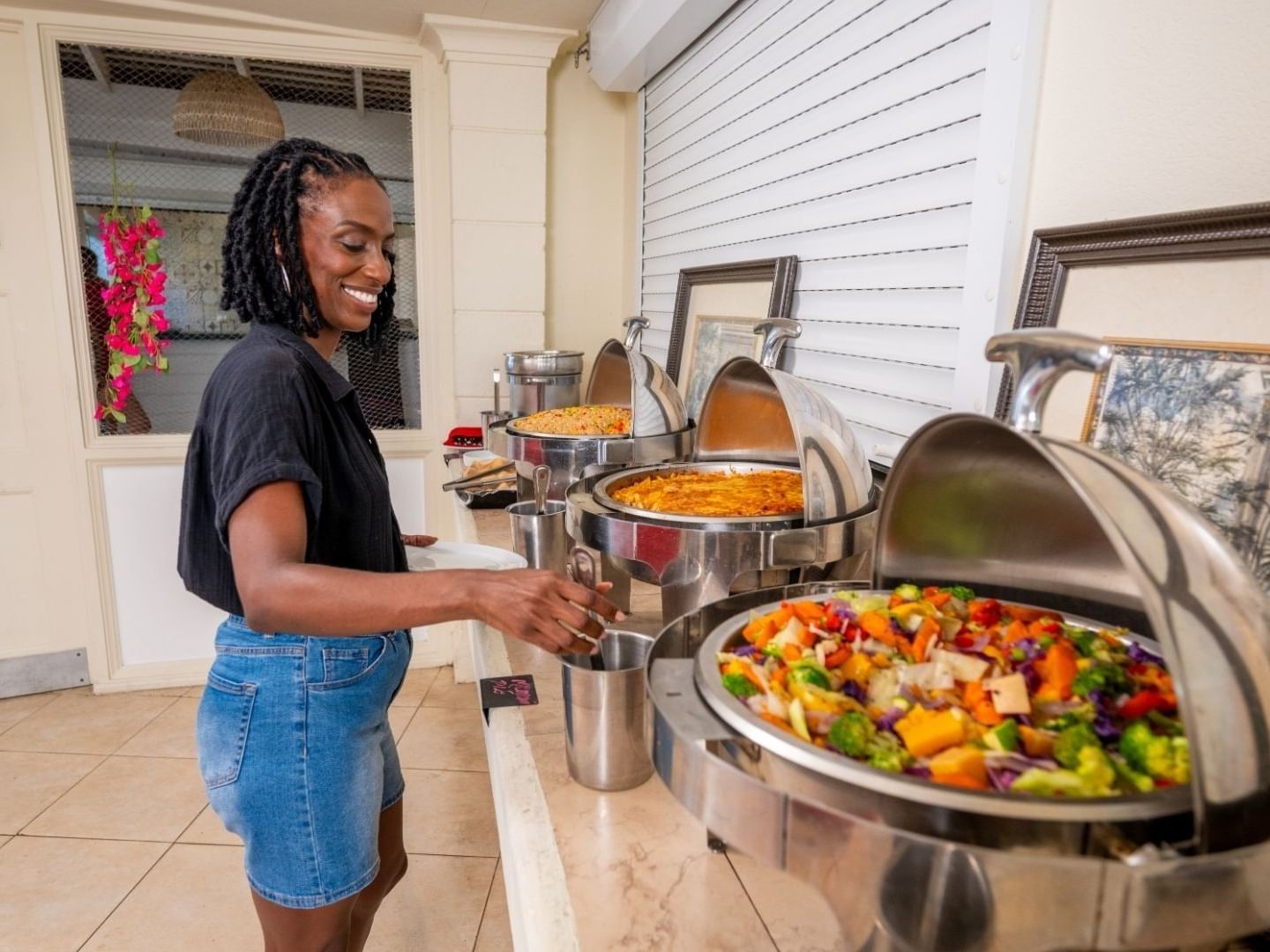 A woman serving food at a buffet station at Savannah Beach Hotel.