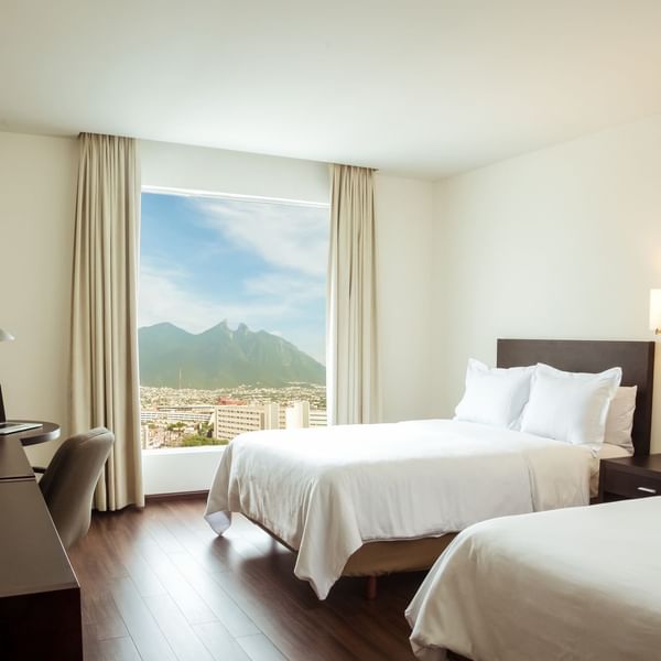 Twin beds in Superior Room with working desk at Fiesta Inn