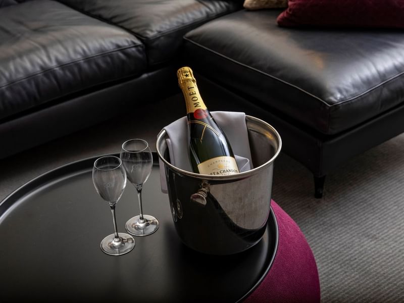 Bottle of champagne in an ice bucket with two flutes on a table in Signature Suite at Sofitel Brisbane Central
