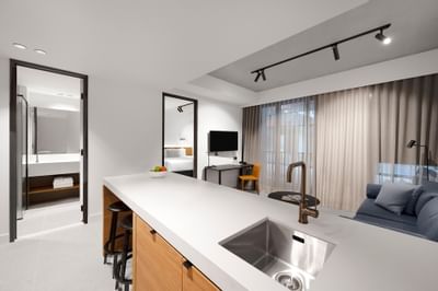 Kitchen counter & living area in a Room at Nesuto Docklands