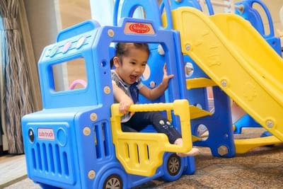 Children happily play on the colorful slide at the Park Hotel Hong Kong party