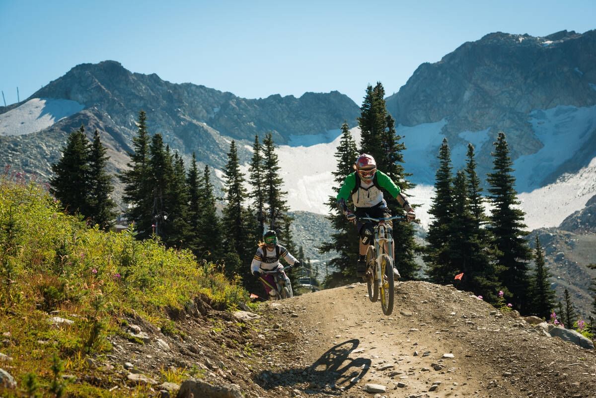 Mountain bikers biking down a hill near Blackcomb Springs Suites