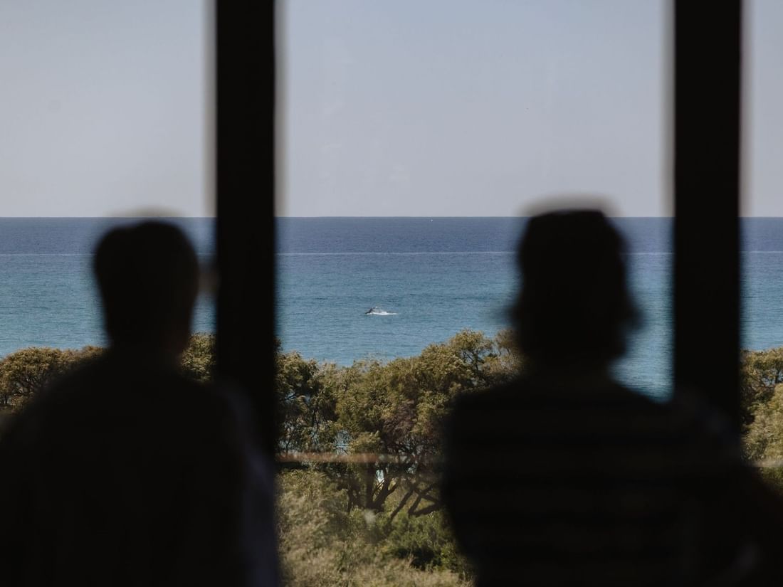 People gazing at the ocean view from inside the Other Side of the Moon Restaurant & Bar at Pullman Bunker Bay Resort