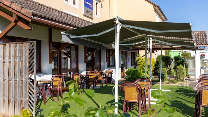 Outdoor table set-up in a restaurant at The Originals Hotels