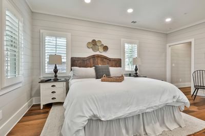 Stylish Deluxe King Cottage with plush bed, wooden floor, and side table lamps by Cottages at Laurel Brooke