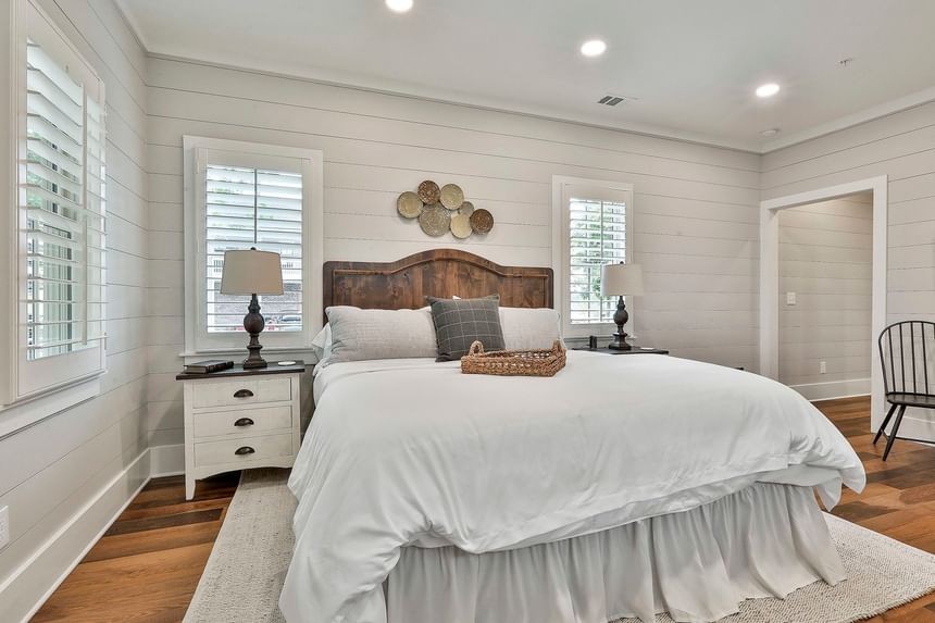 Stylish Deluxe King Cottage with plush bed, wooden floor, and side table lamps by Cottages at Laurel Brooke