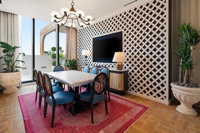 Elegant dining area with a lattice wall, round table, and chandelier at 27 Wynwood