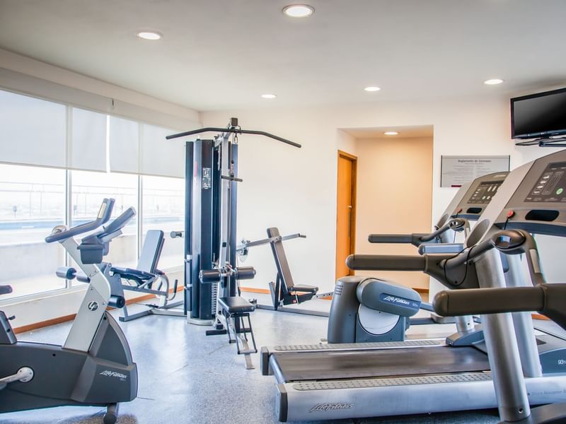 Gym with equipment and window with a view at Fiesta Inn