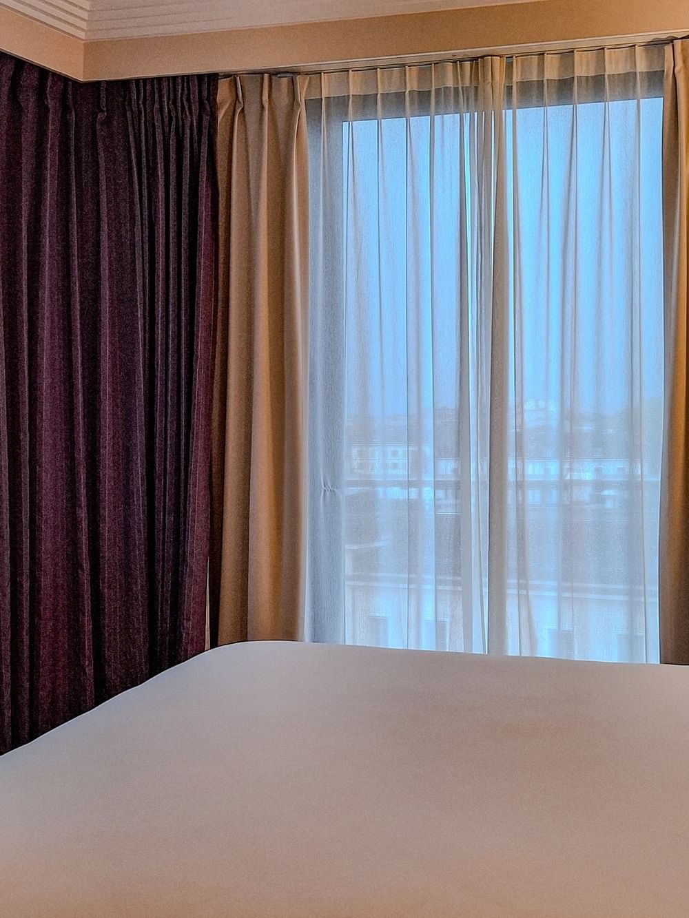 Une chambre Supérieure avec un grand lit et des rideaux à l'hôtel Warwick Geneva à Genève.