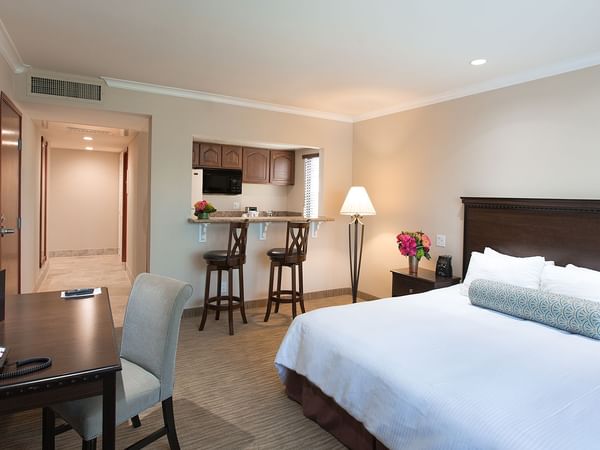 King bed in hotel suite with kitchen