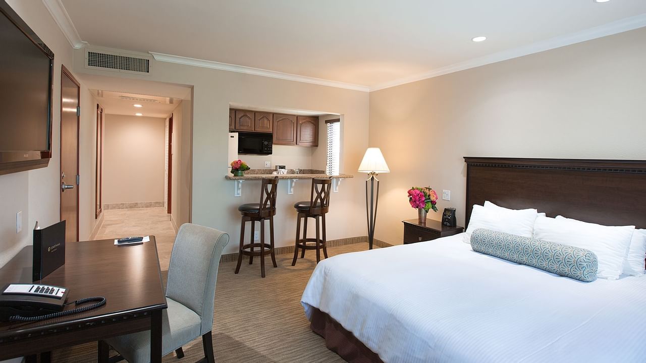 King bed in hotel suite with kitchen