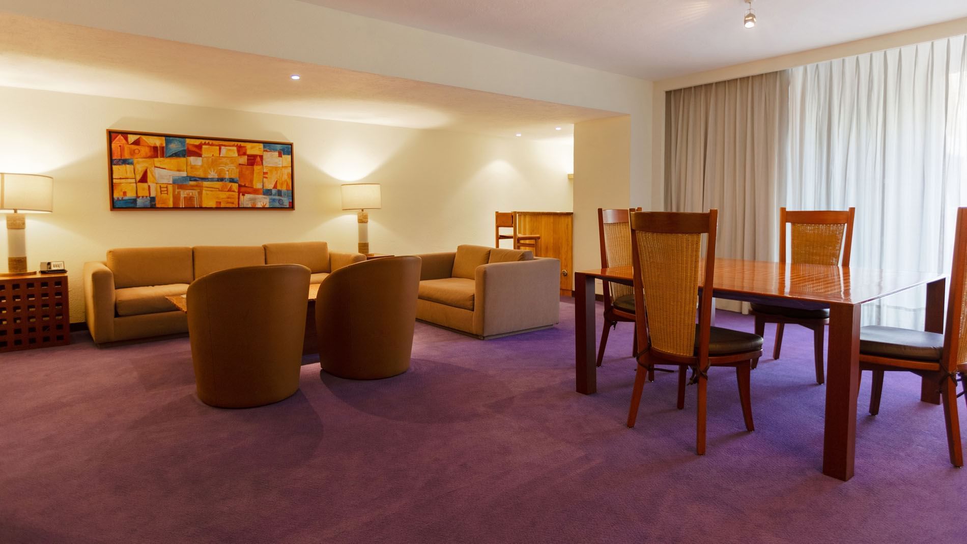 King Master Suite lounge featuring purple flooring, tan armchairs, and colorful wall art at Camino Real Polanco Mexico