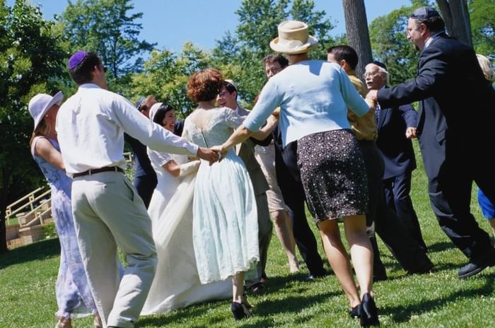 Jewish weddings in Berkshire featuring a group of dancing guests doing the Hora