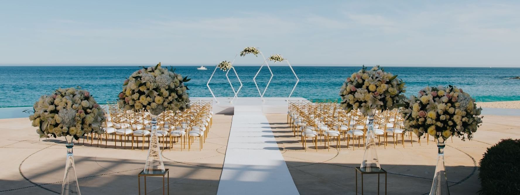 Beautiful outdoor wedding ceremony setup on a patio overlooking the ocean at Marquis Los Cabos Resort