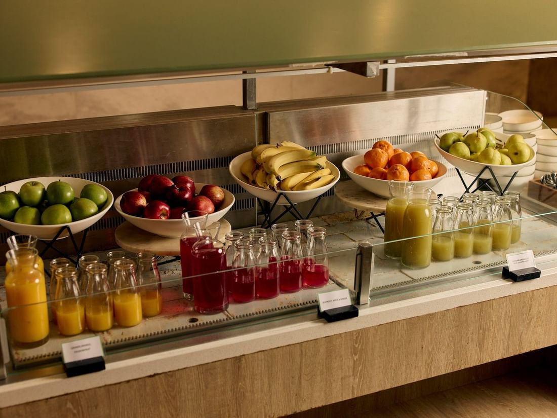 Buffet station with fresh fruit bowls and juice bottles at The Cliveden at Pullman East Melbourne