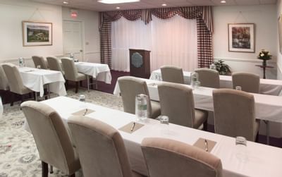 Meeting room setup with classroom-style tables and chairs facing the podium at Farmington Inn and Suites
